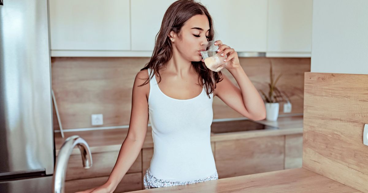 Woman drinking water in kitchen
