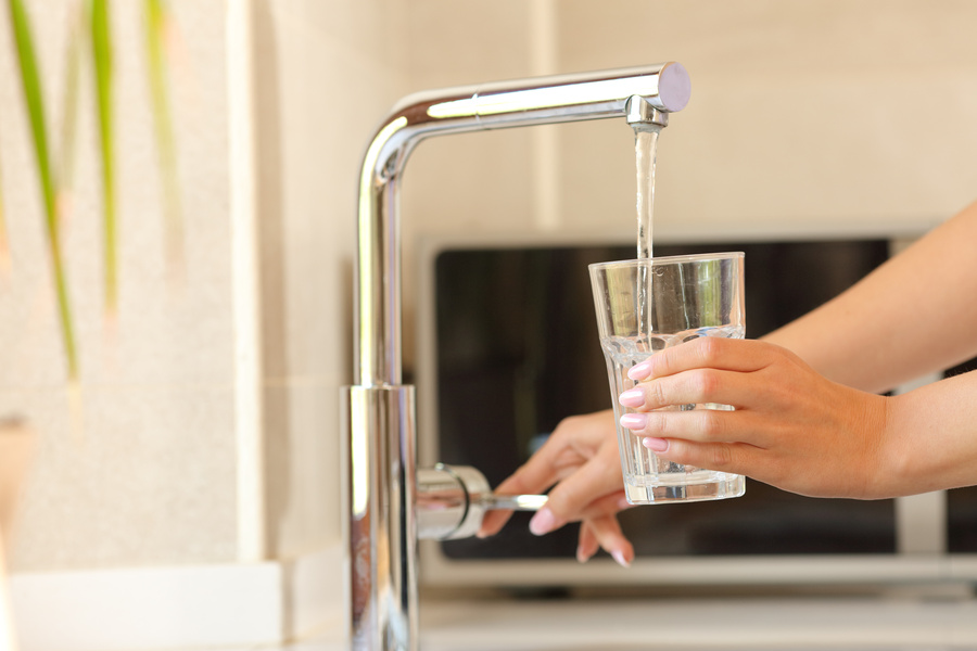 Woman hands filling a glass of tap water
