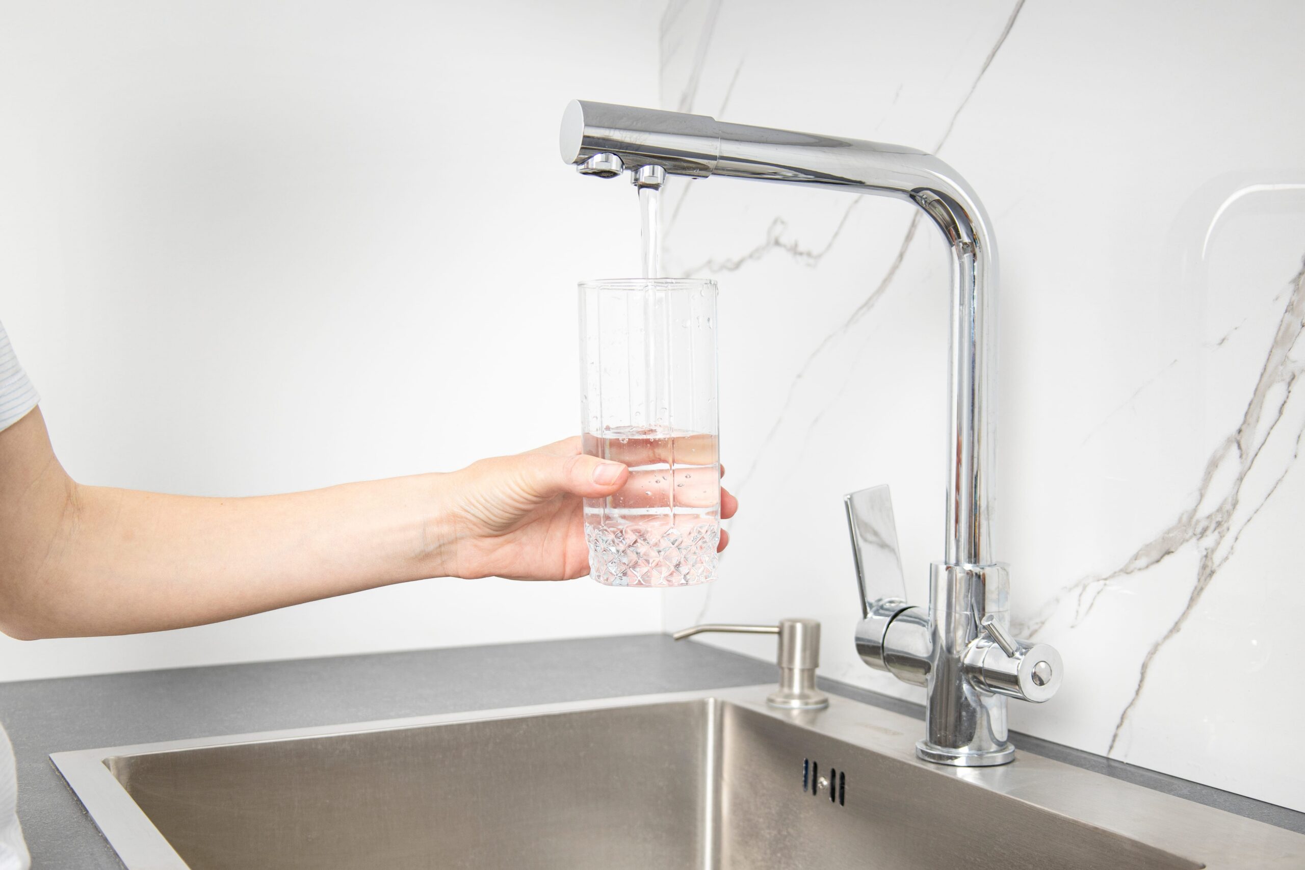 woman hand filling filtered water in a glass
